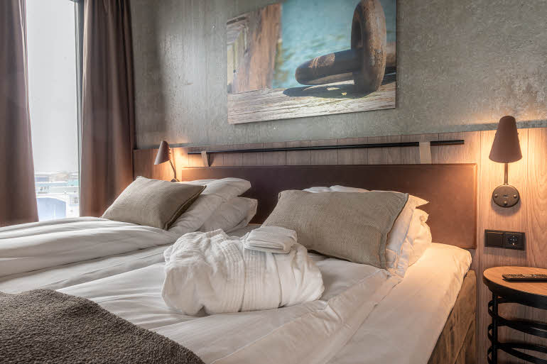 bathrobe on bed in master suite at scandic sortland